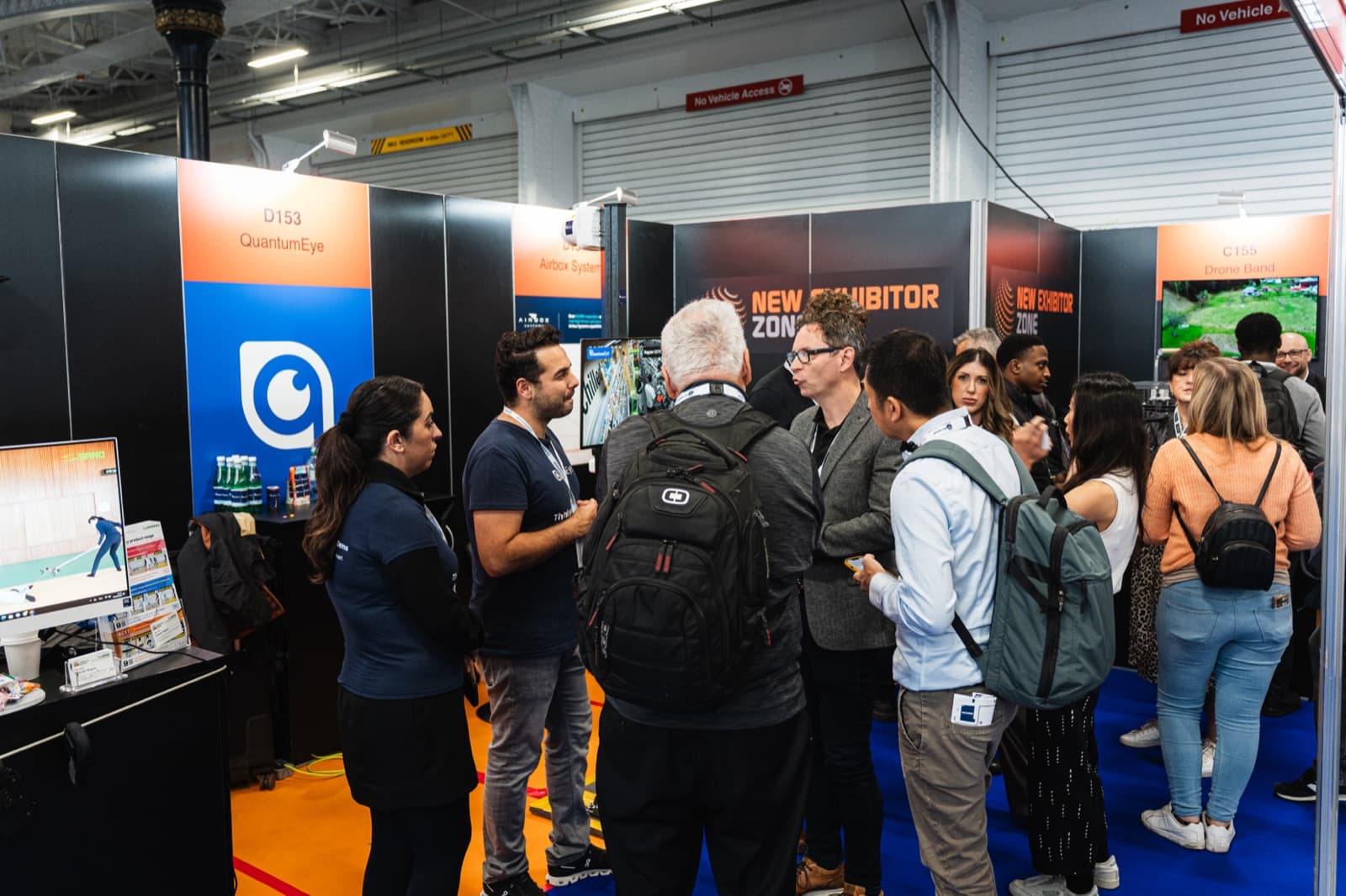 A crowd of visitors around the QuantumEye stand (D153) as the team demonstrates the platform at a UK retail security exhibition.